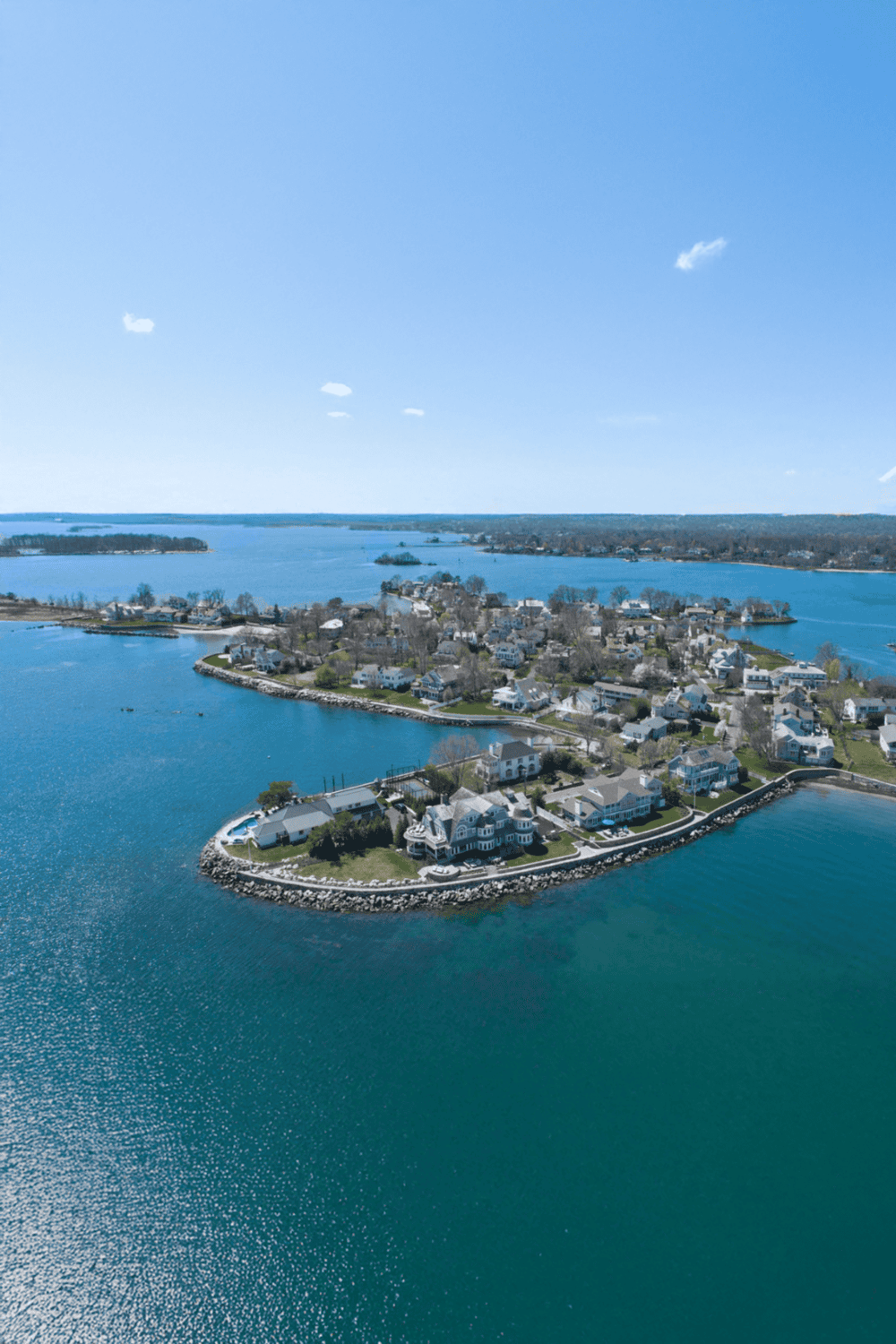 Aerial view of waterfront homes on a coastal island with ocean scenery, perfect for navigation and real estate insights.