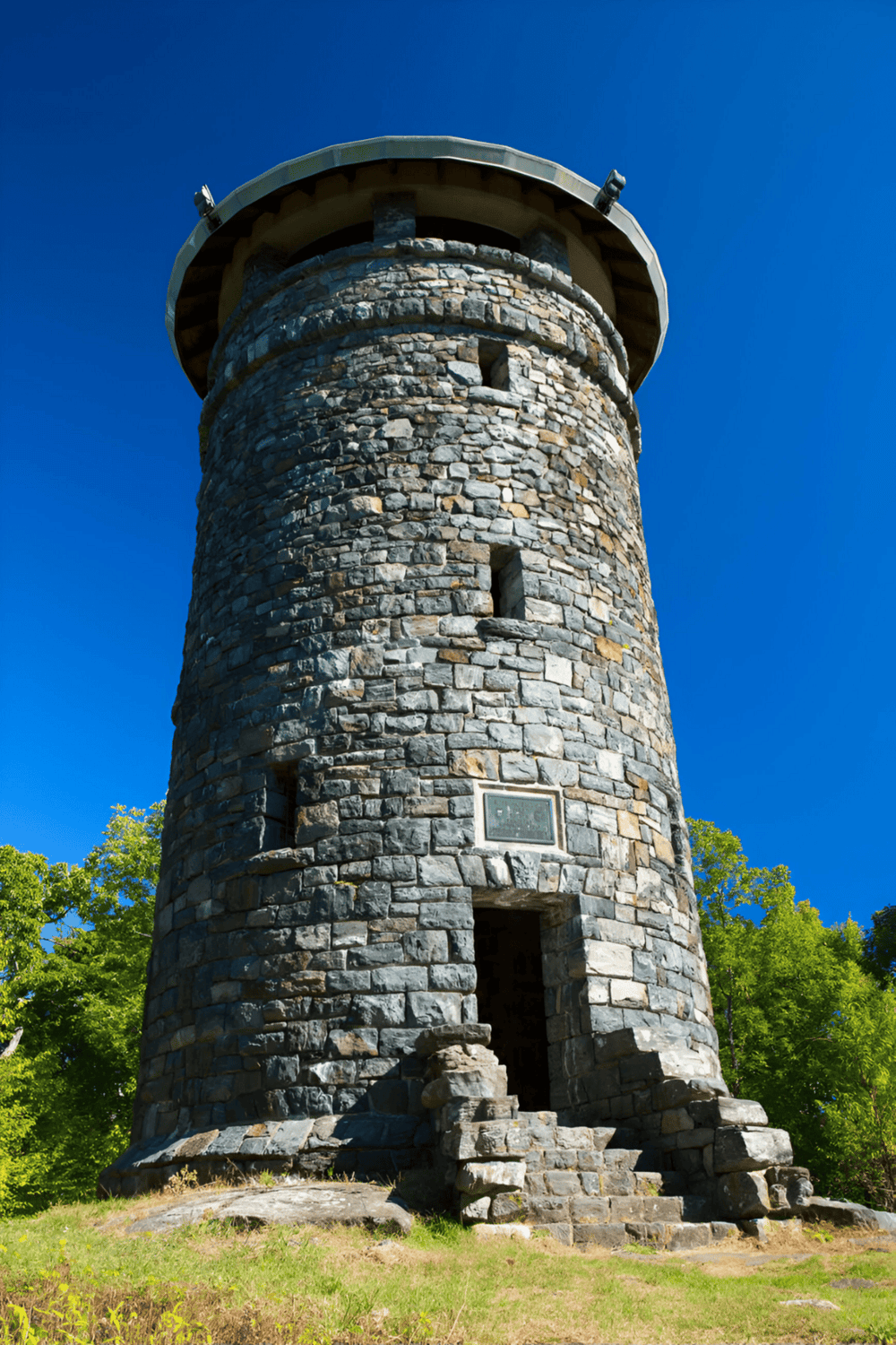 Stone lookout tower with stairs and blue sky at QuestForDirections site, highlighting navigation and outdoor exploration.