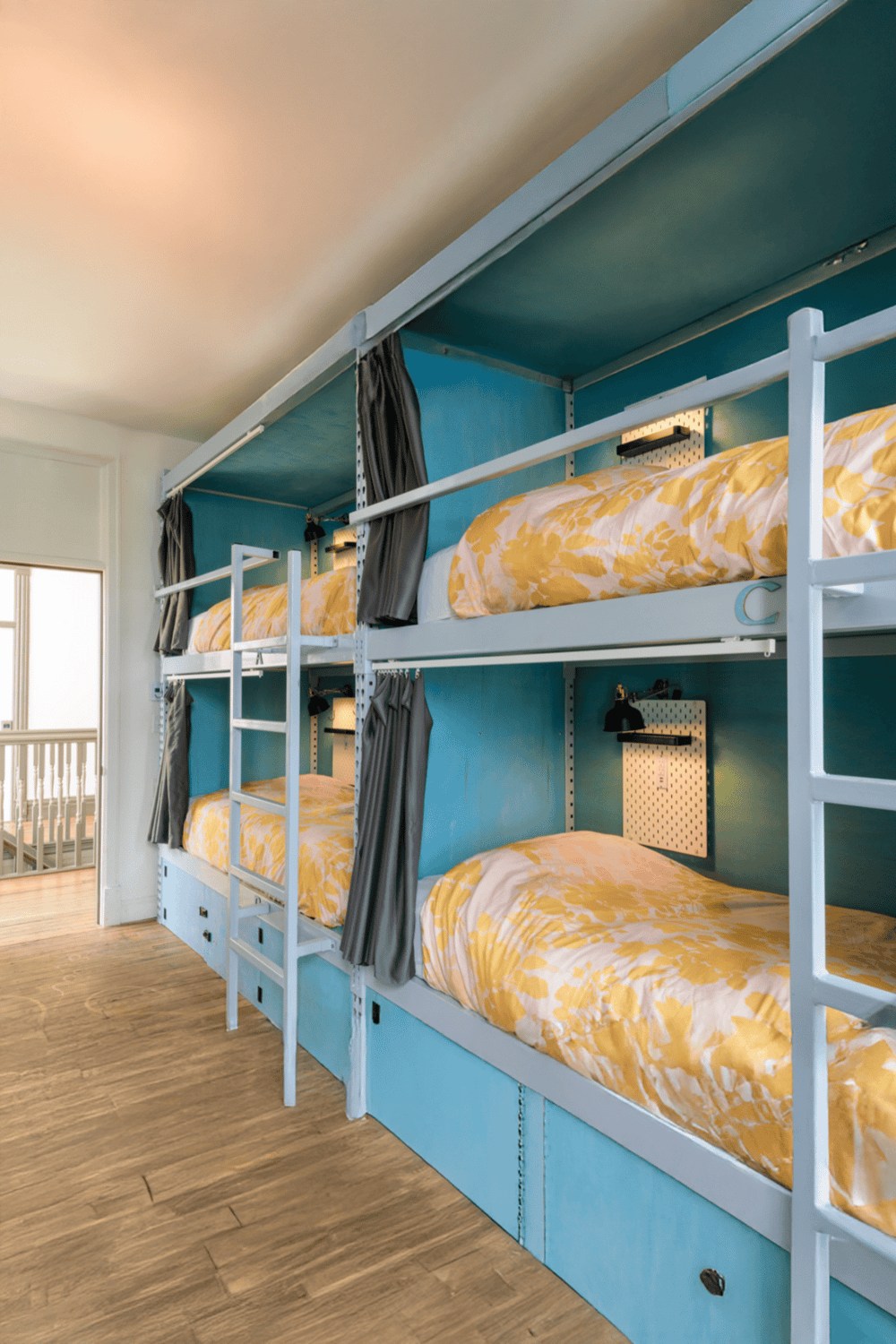 Bunk beds in a modern hostel room with colorful decor and functional design.