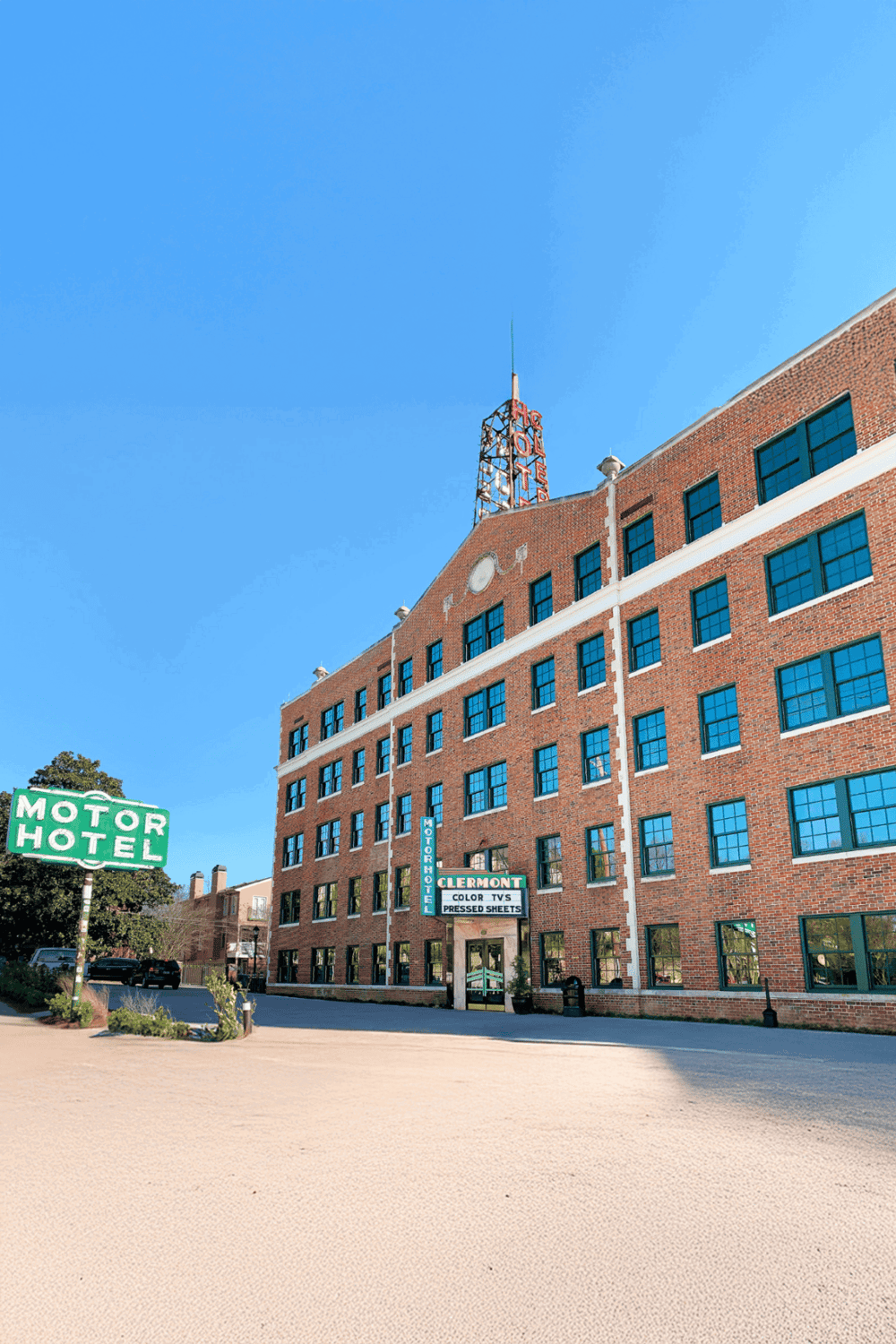 Modern brick motel building with vintage signage, located in a historic downtown area.