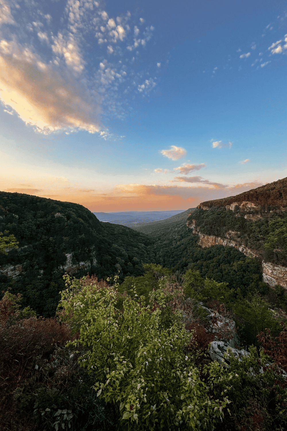 Scenic view of lush green valleys and rolling hills at sunset, illustrating outdoor adventures with QuestForDirections.