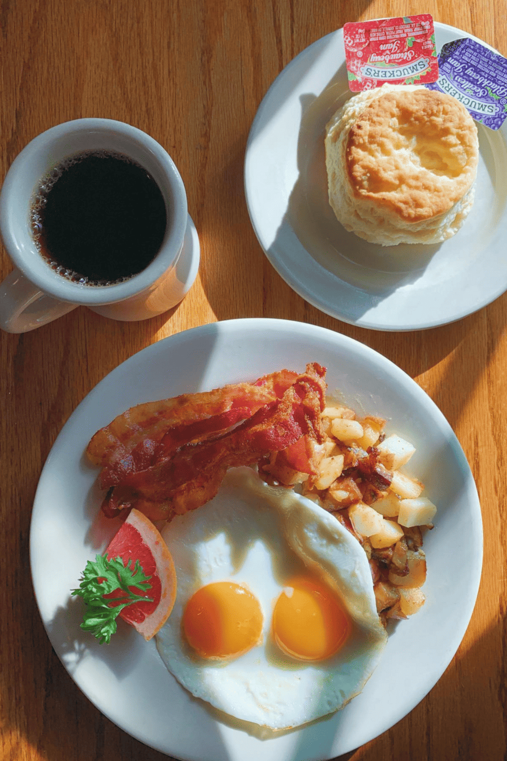 Coffee and breakfast plate with eggs, bacon, hash browns, and biscuit, served at QuestForDirections.