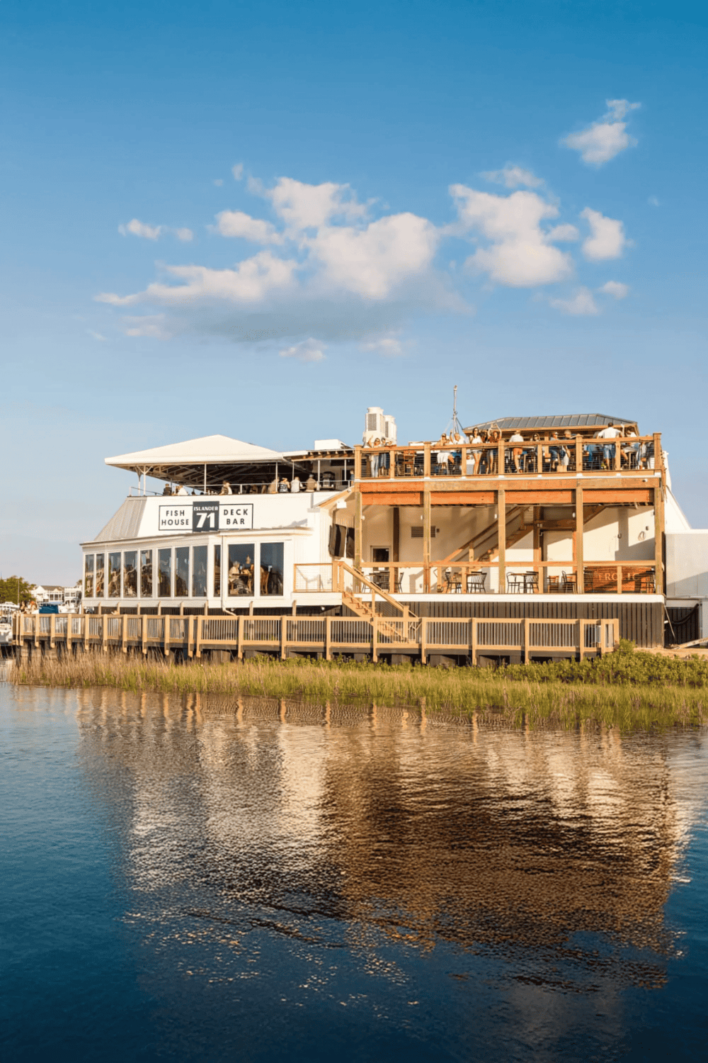 Floating waterfront restaurant with outdoor deck, vibrant atmosphere, and panoramic water views.