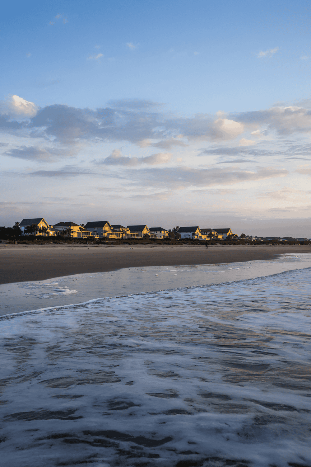 Seaside houses along the beach at sunset, showcasing coastal living and ocean views.