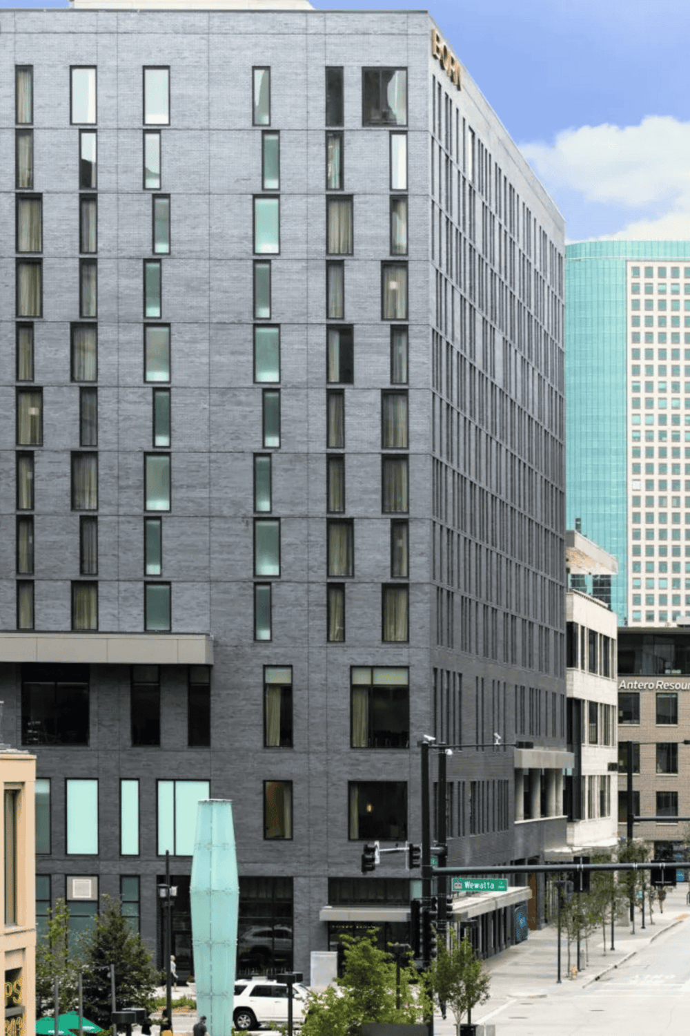 Modern commercial office building in a downtown cityscape with QuestForDirections signage.