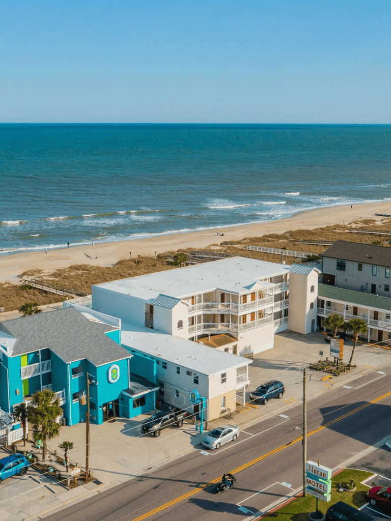 Beachfront hotel on the coast with colorful buildings and ocean views.