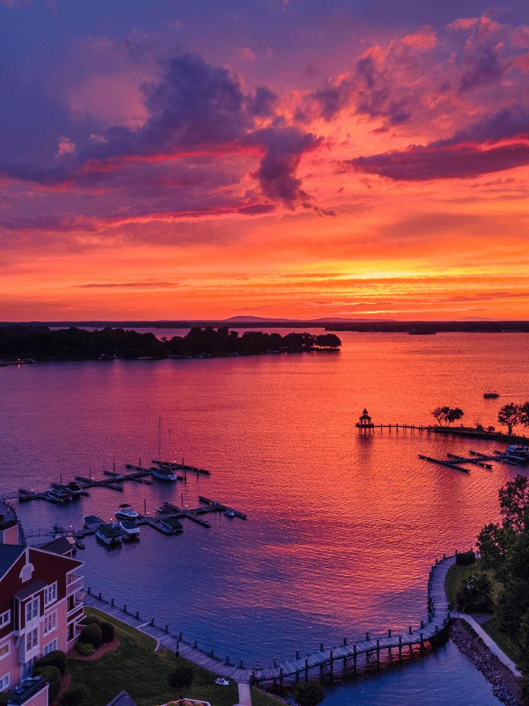 Serene sunset over a marina with boats and waterfront homes, ideal for travel and leisure.
