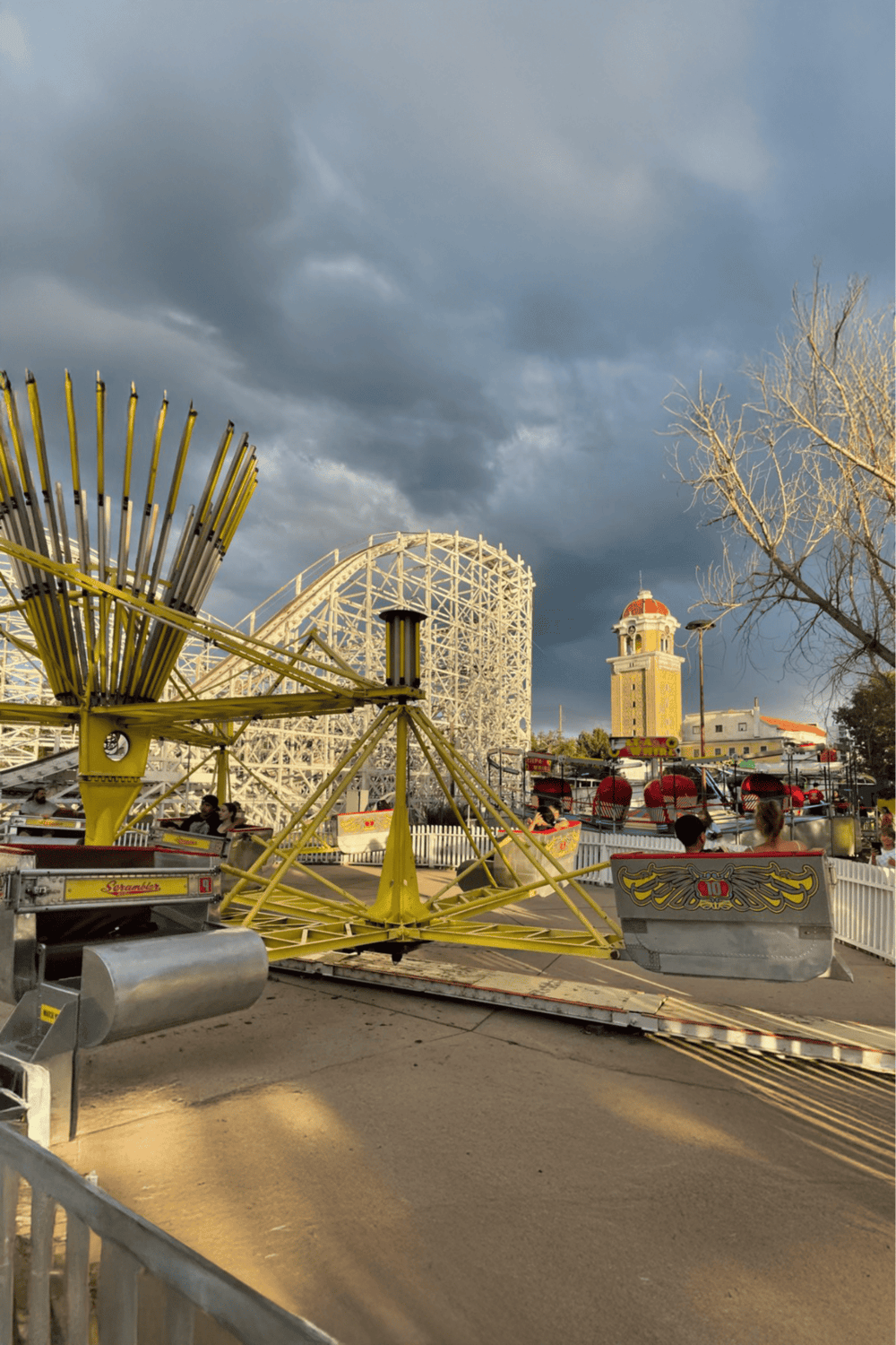 Colorful amusement park rides with roller coaster and ferris wheel, fun destination for all ages.