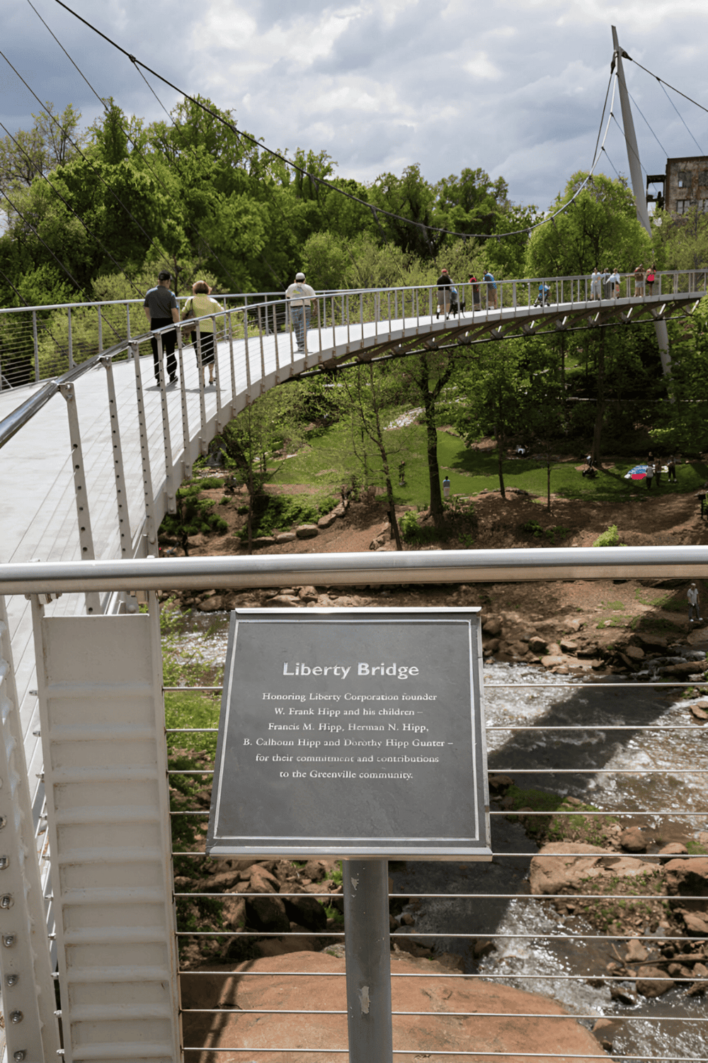 1. Modern Liberty Bridge in Greenville, with visitors enjoying scenic views and lush greenery.
