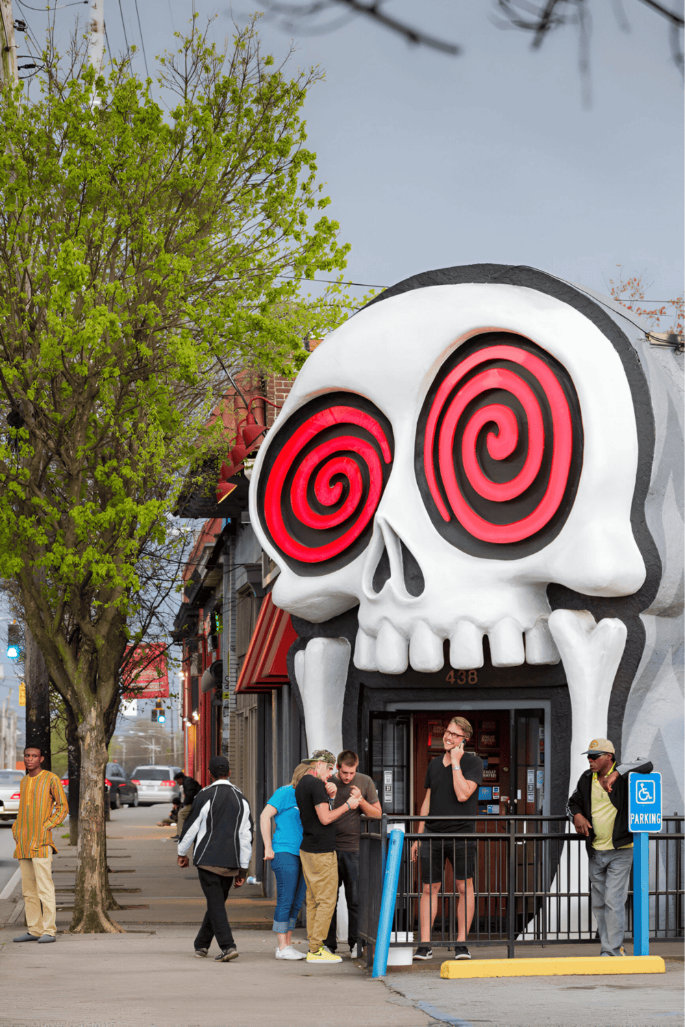 Vibrant skull storefront with hypnotic spiral eyes, popular nightlife attraction in downtown.