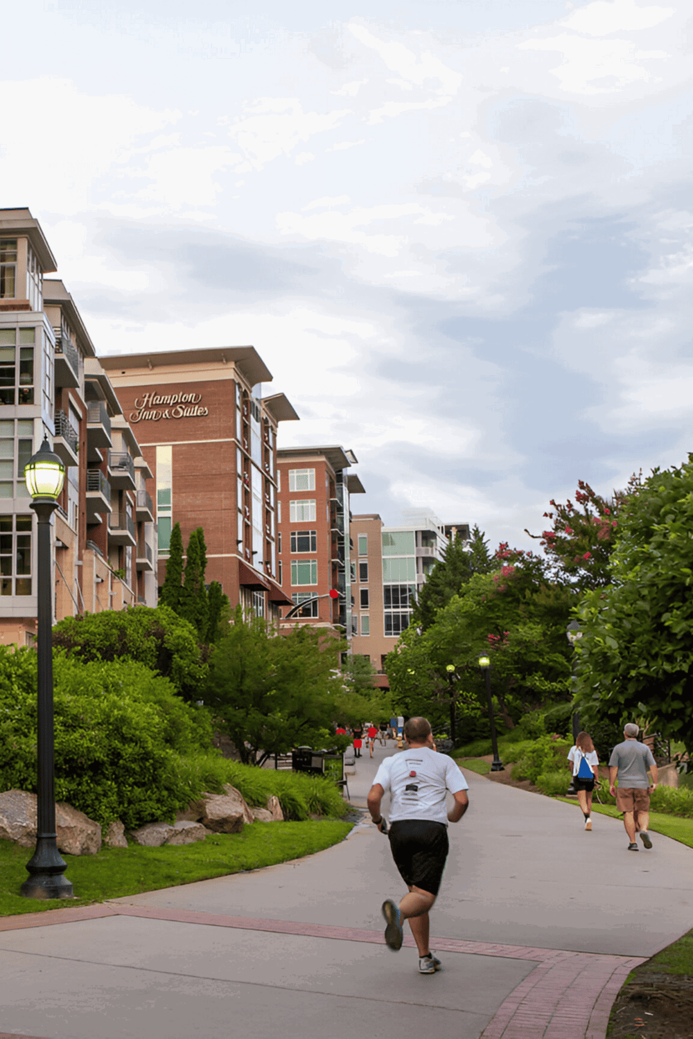 Modern urban trail near Hampton Inn & Suites with people walking and running.