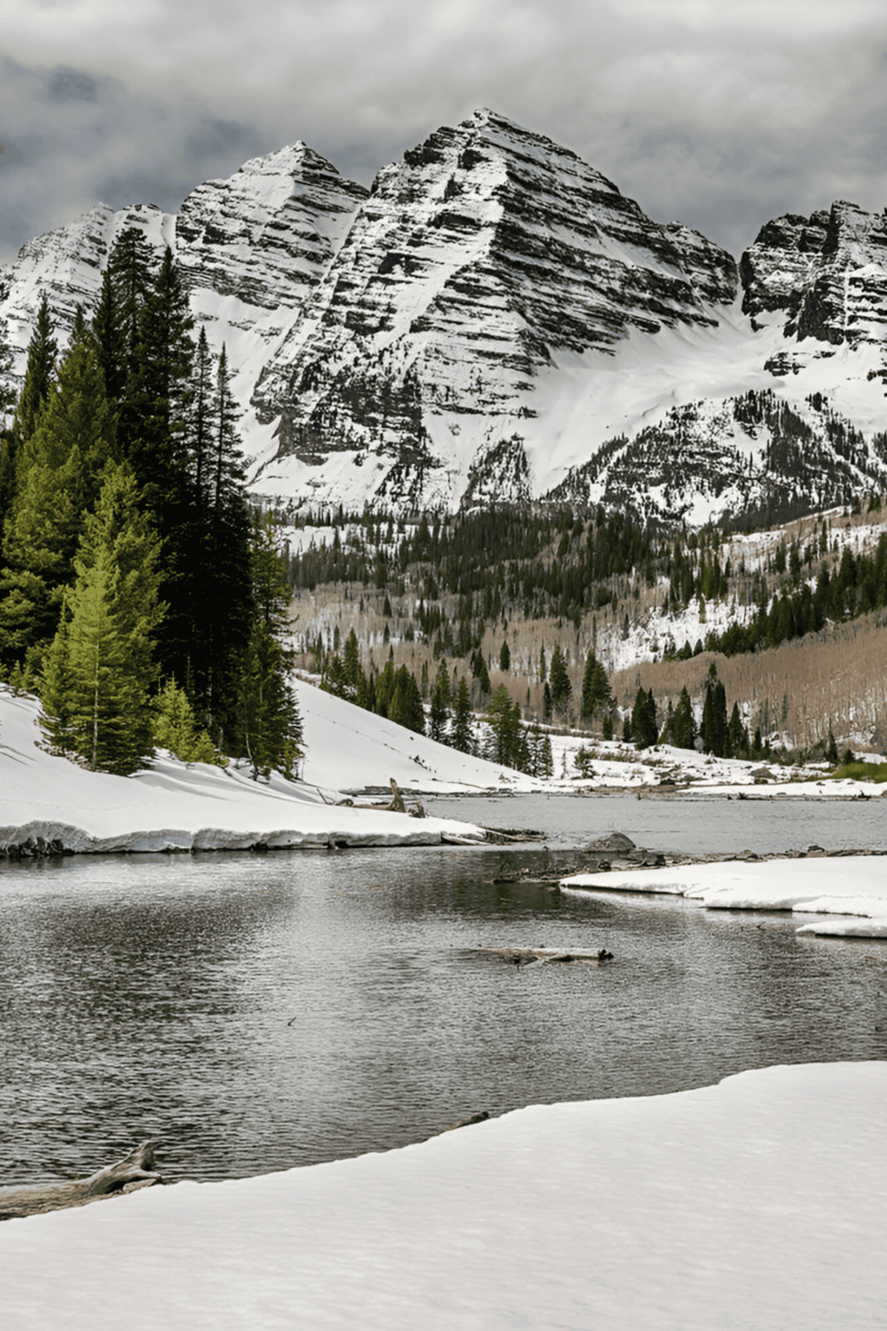 Snow-capped mountains and tranquil lake in Glacier National Park, Montana, scenic wilderness travel destination.