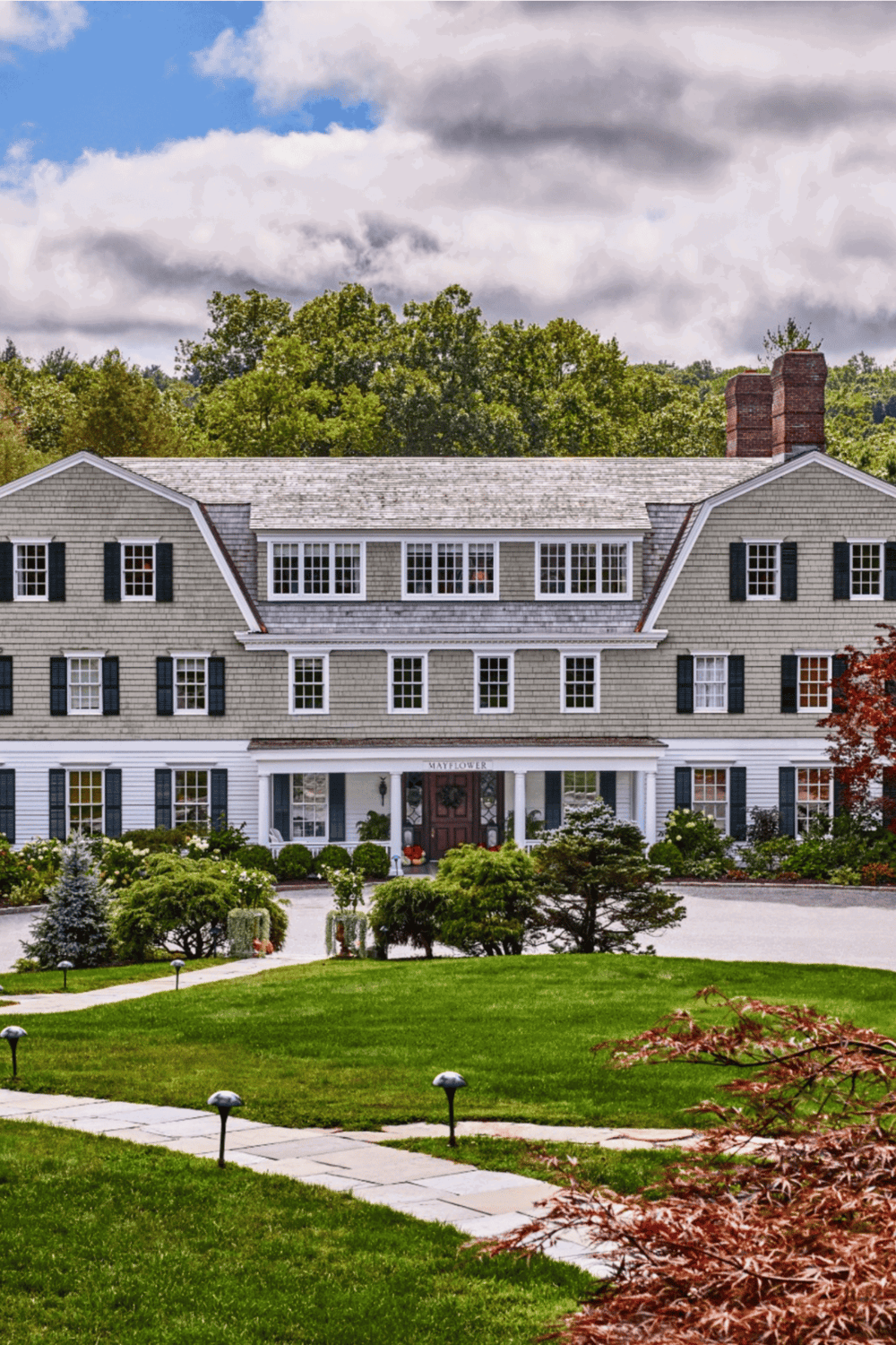 A charming historic house surrounded by lush greenery, exemplifying traditional American architecture and scenic landscape.