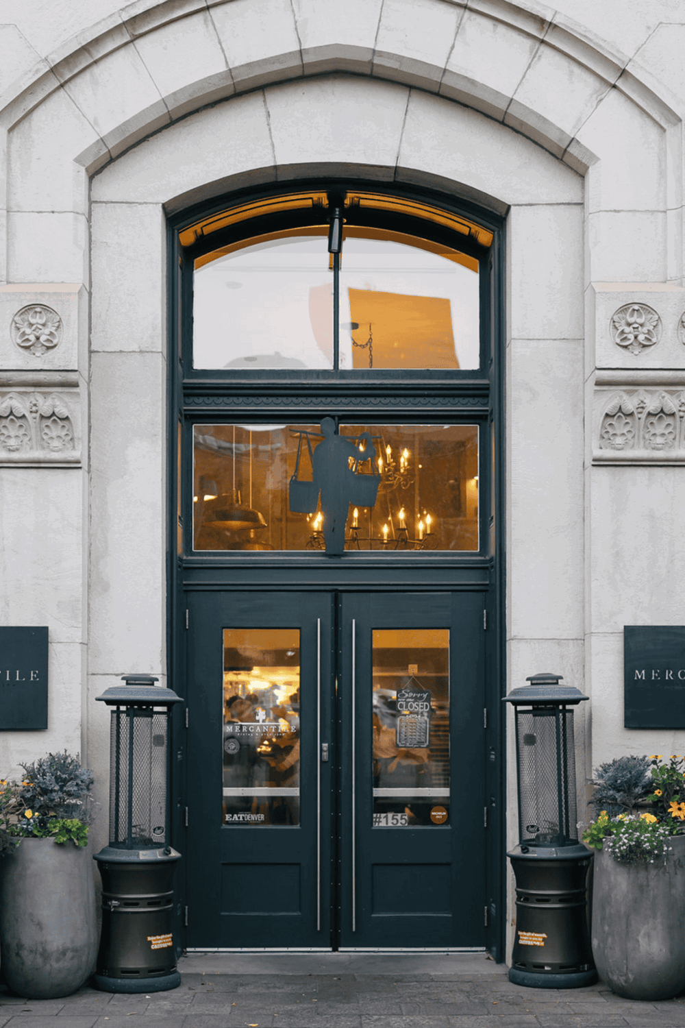 Charming storefront entrance of a restaurant with elegant stone architecture and inviting interior lighting.