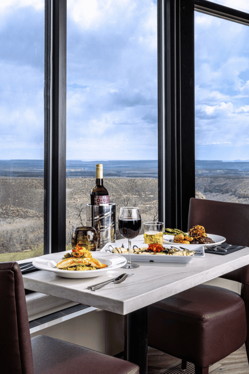 Relaxing fine dining with panoramic mountain views and wine in a modern restaurant.
