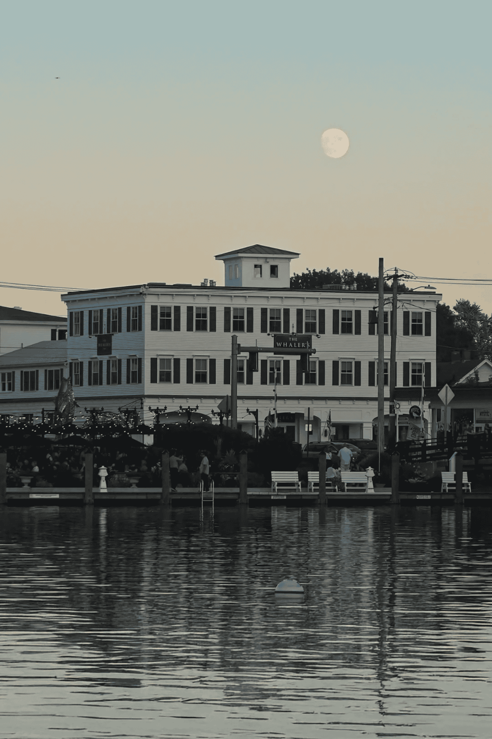 Bright moon over waterfront building, iconic destination for travel and navigation assistance.