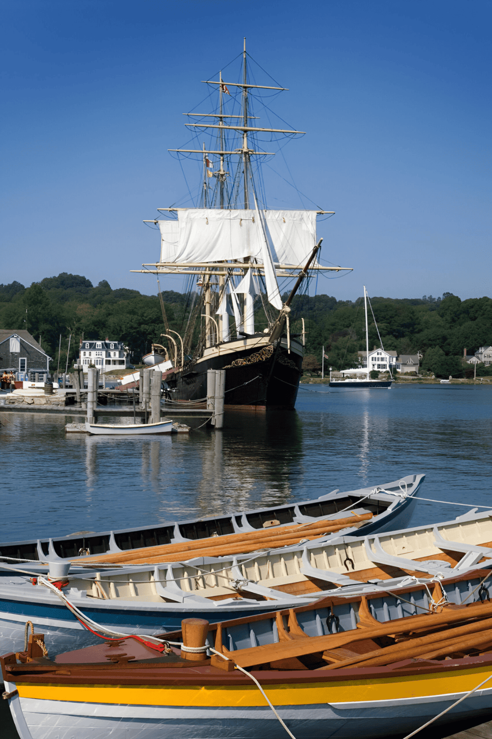 Sailing ship docked at marina on a clear day, promoting maritime navigation and travel services.