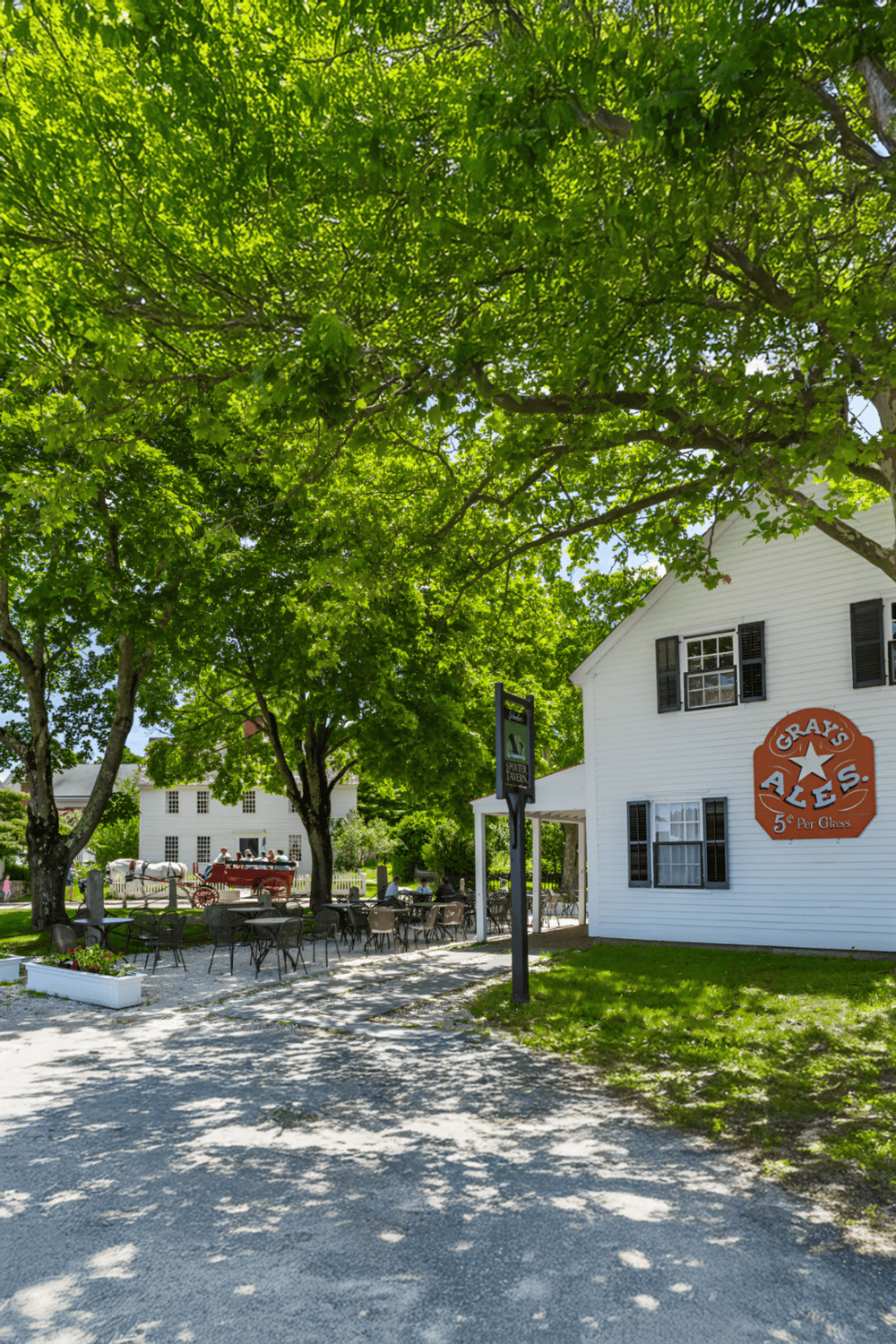 Colorful farmhouse restaurant with outdoor seating under trees, perfect for dining and exploring local attractions.