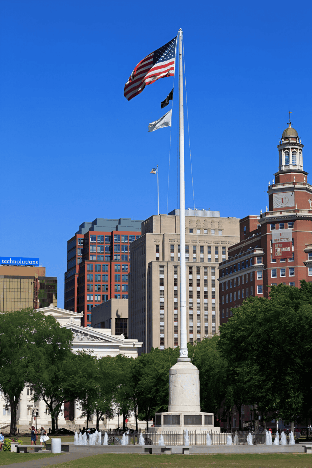 Flagpole with American flag in downtown cityscape, QuestForDirections focus, urban landmarks, travel, navigation, directions, city guide.