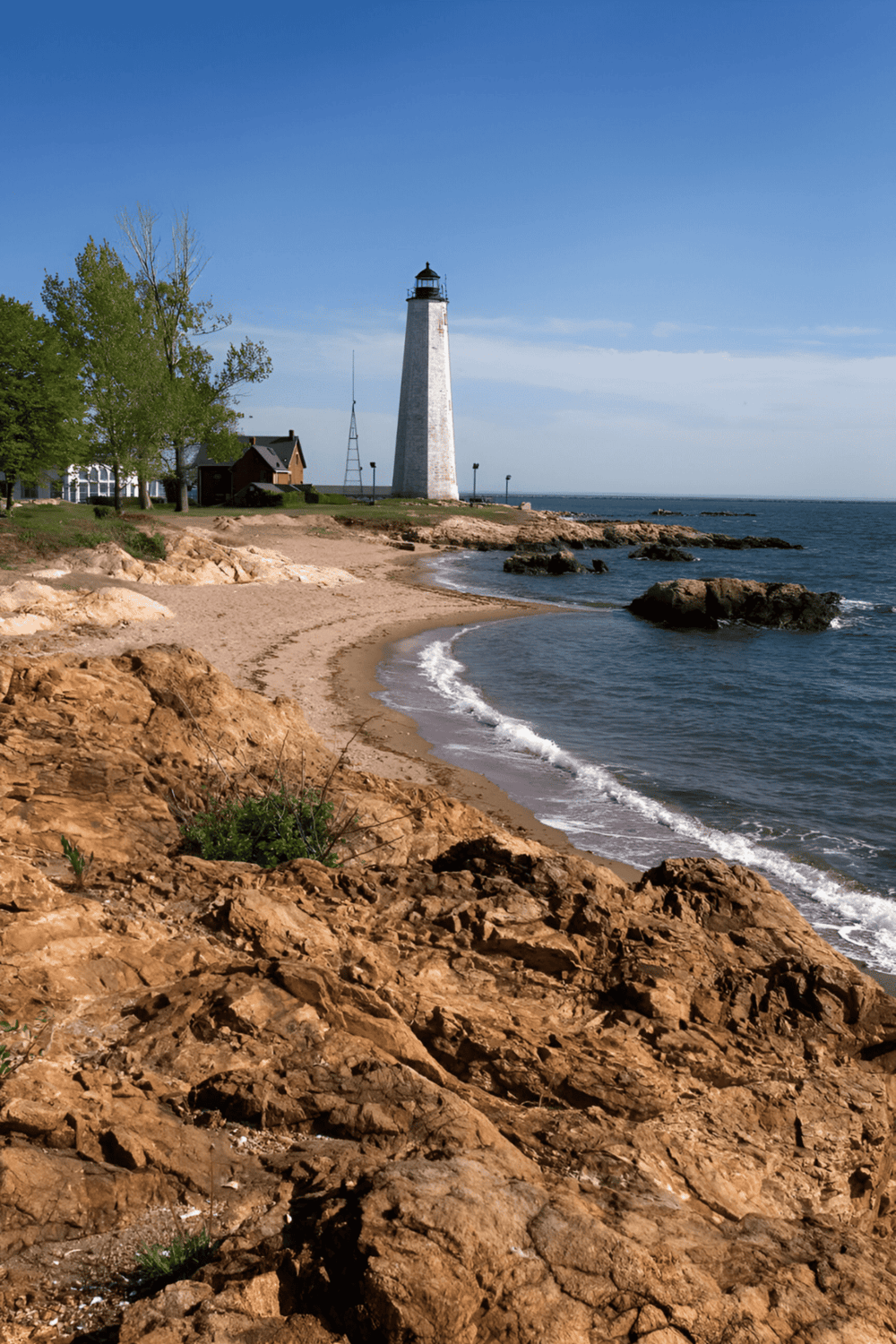 Lighthouse on rocky shoreline, scenic coastal view, Quest for Directions navigation tips, lighthouse sightseeing, ocean navigation.