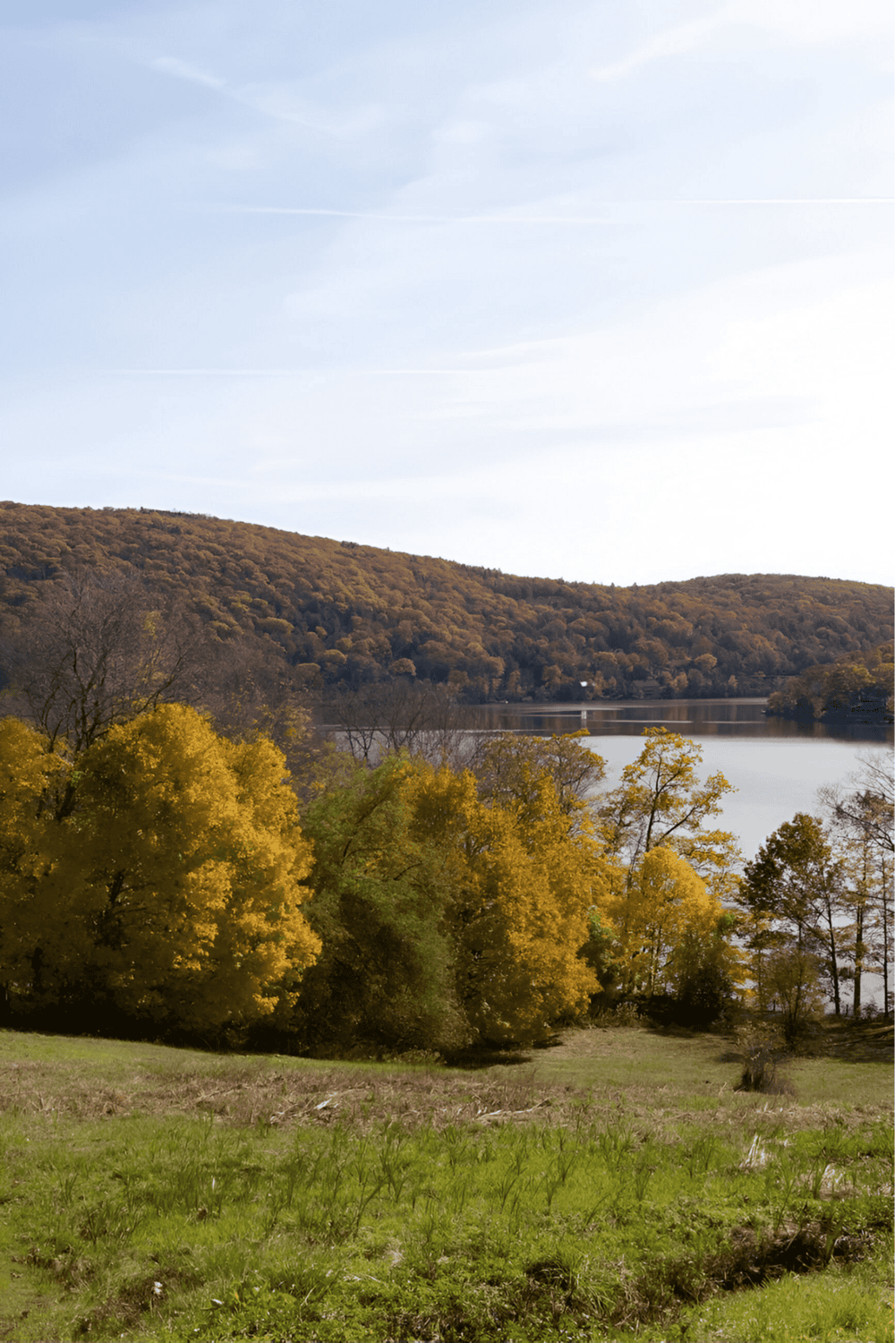 Vibrant autumn landscape with colorful trees, lake, and rolling hills, perfect for outdoor adventure and nature exploration.