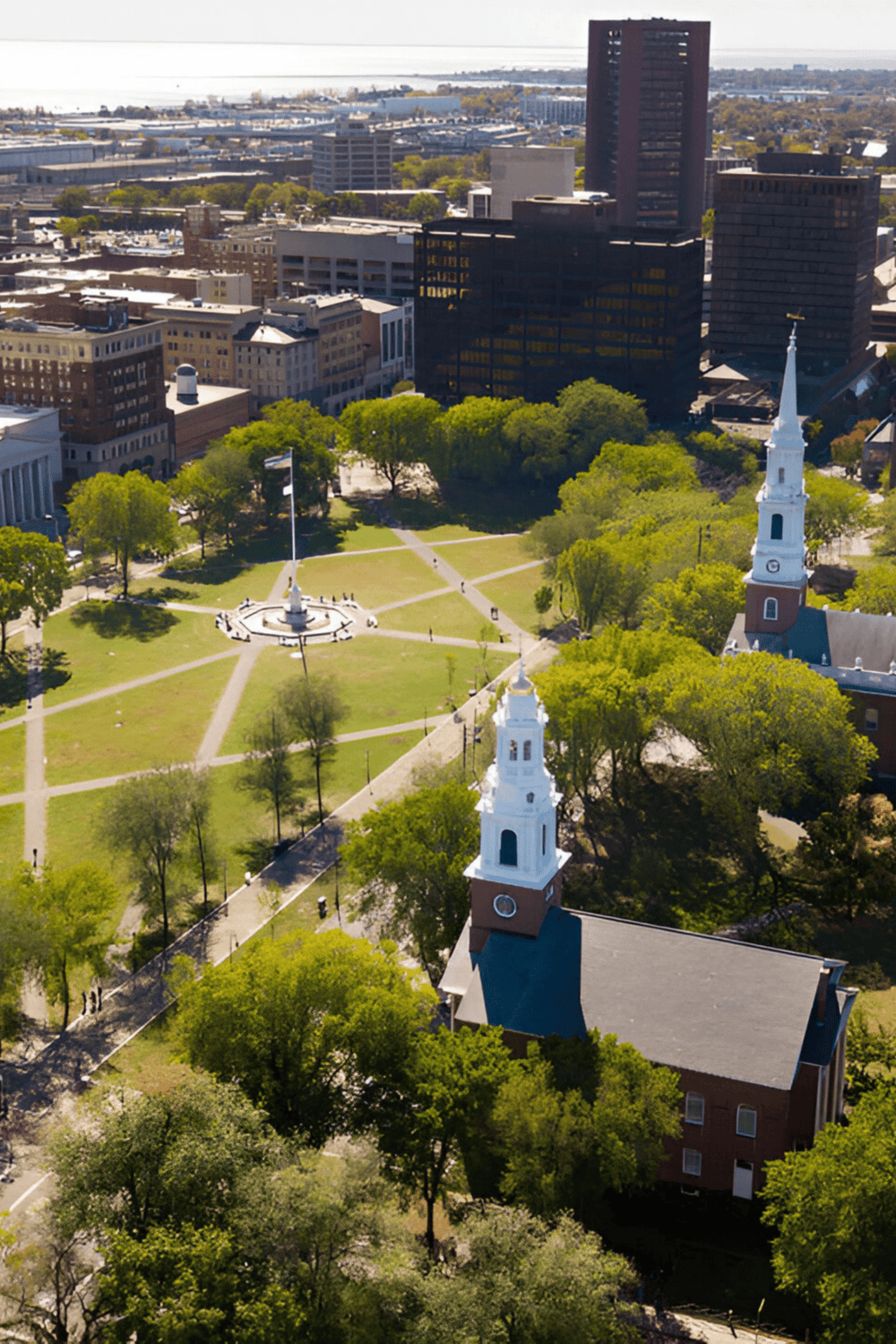 1. Aerial view of QuestForDirections park with historic church and city skyline in the background.