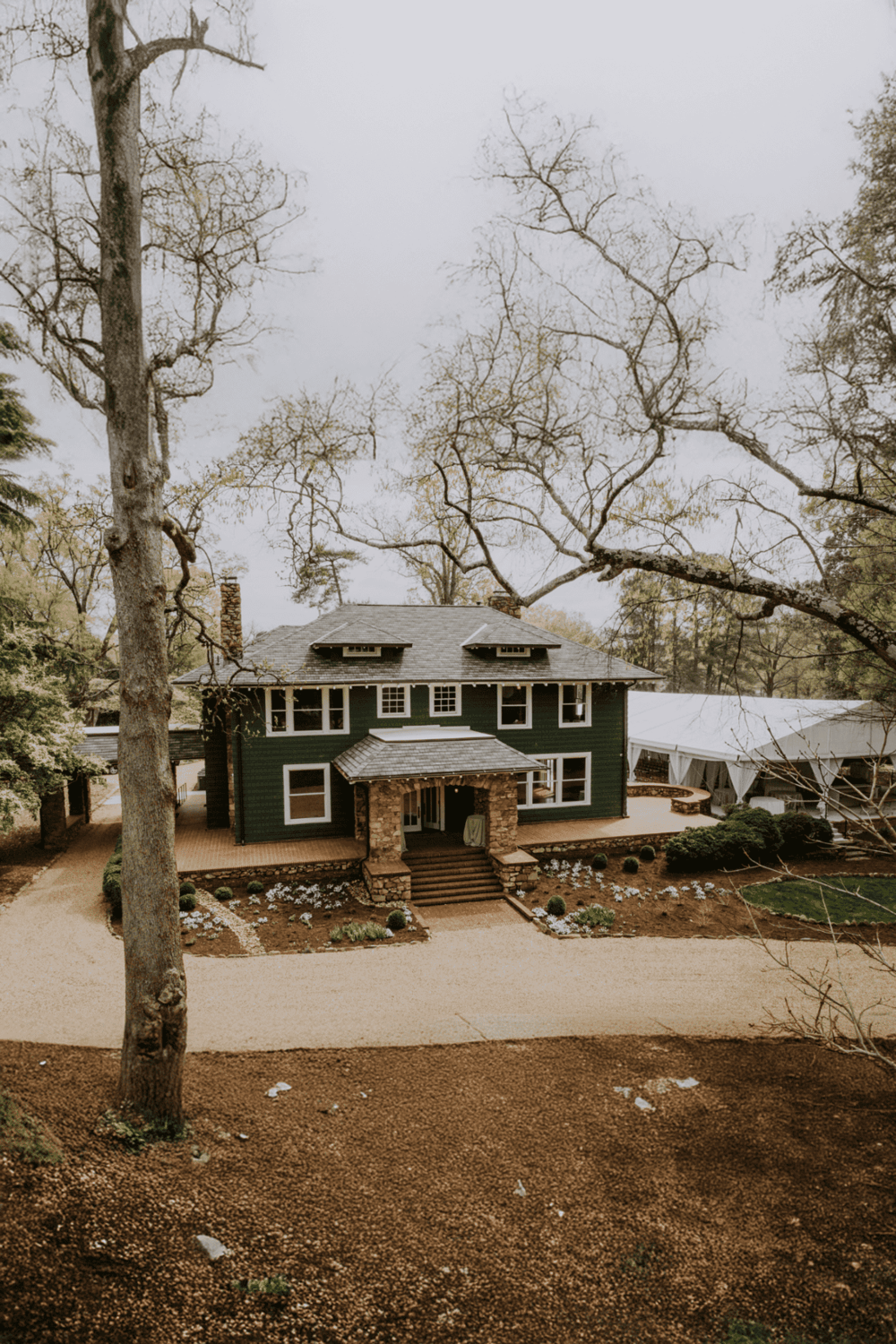 Charming historic house set in picturesque landscape, surrounded by trees and lush garden.