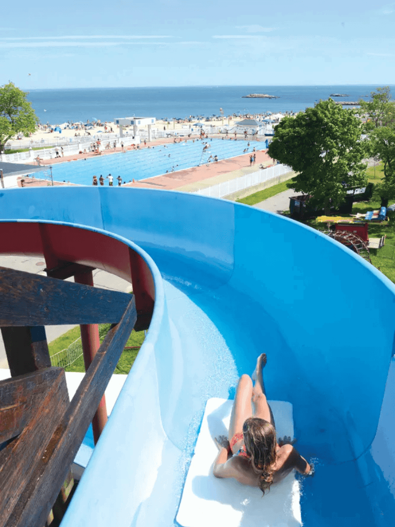 Water park water slide with ocean view and children enjoying summer summer vacation.