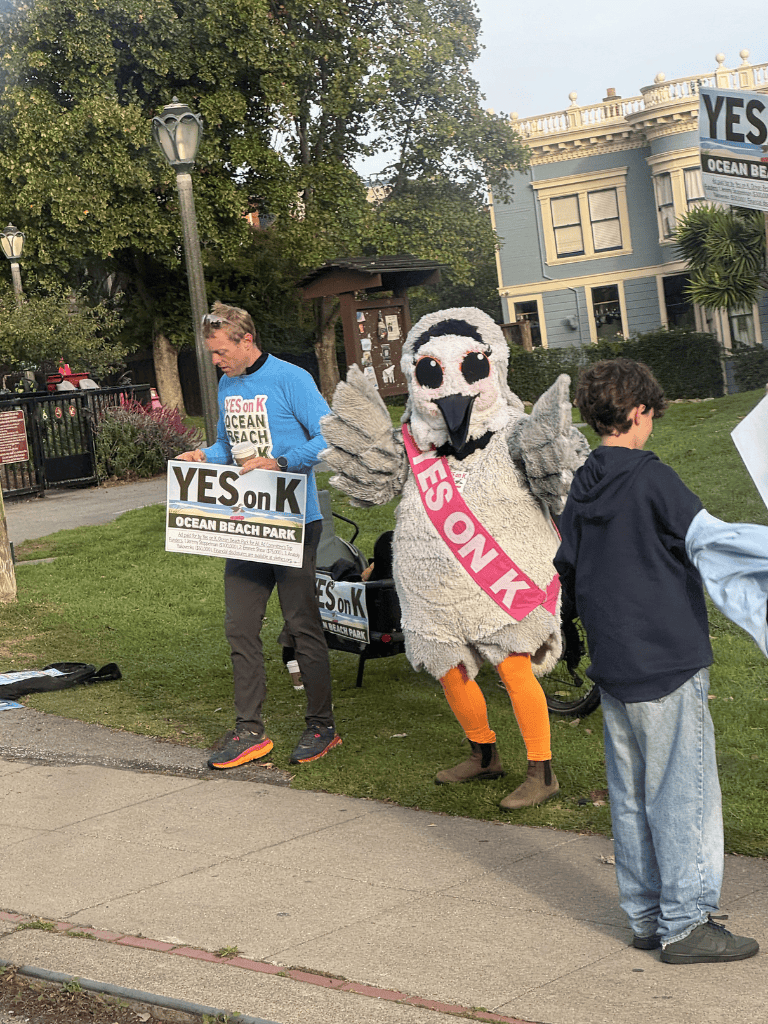 Yes on K Ocean Beach Park mascot at climate change rally for ocean conservation awareness.