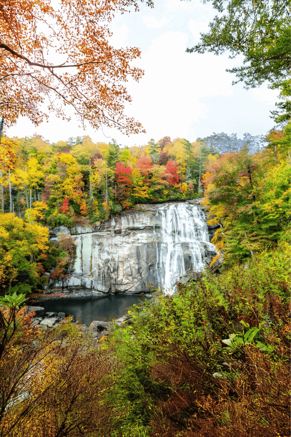 Serene fall landscape with waterfall and colorful autumn trees, perfect for nature & travel SEO.