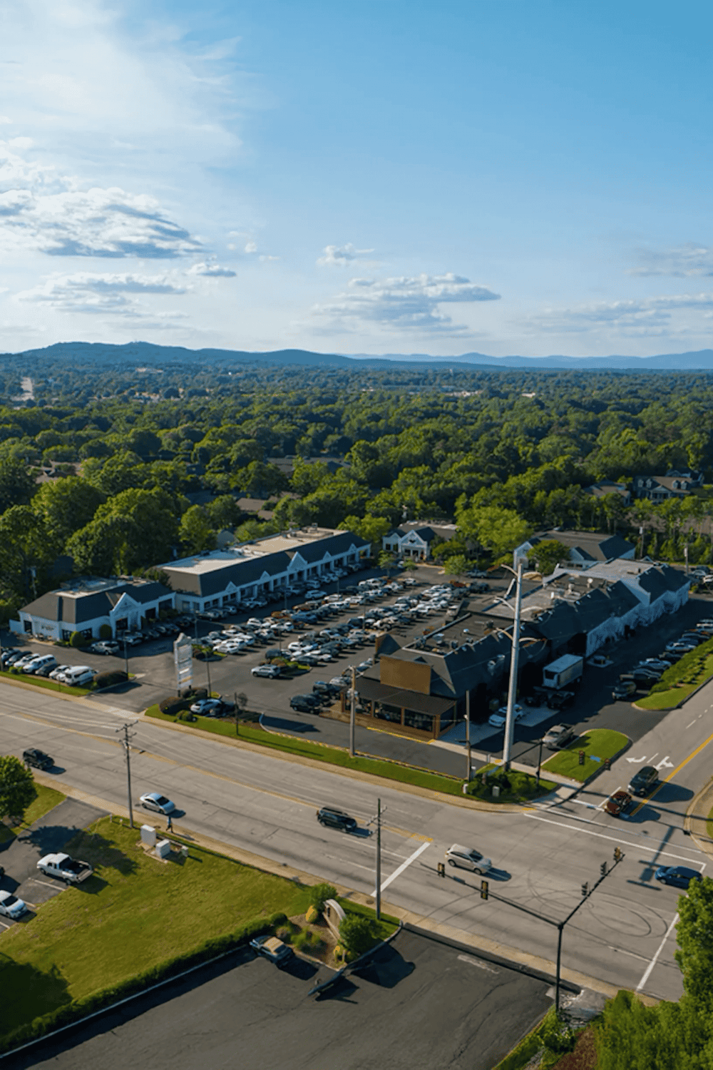 Convenient shopping center parking with scenic mountain views behind, ideal for local errands and shopping trips.