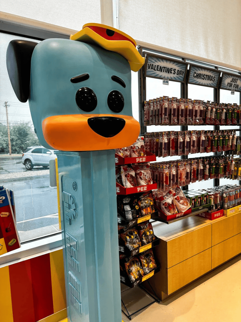 Cute cartoon dog figure with a taco hat, toy store display for holiday gifts and candy.