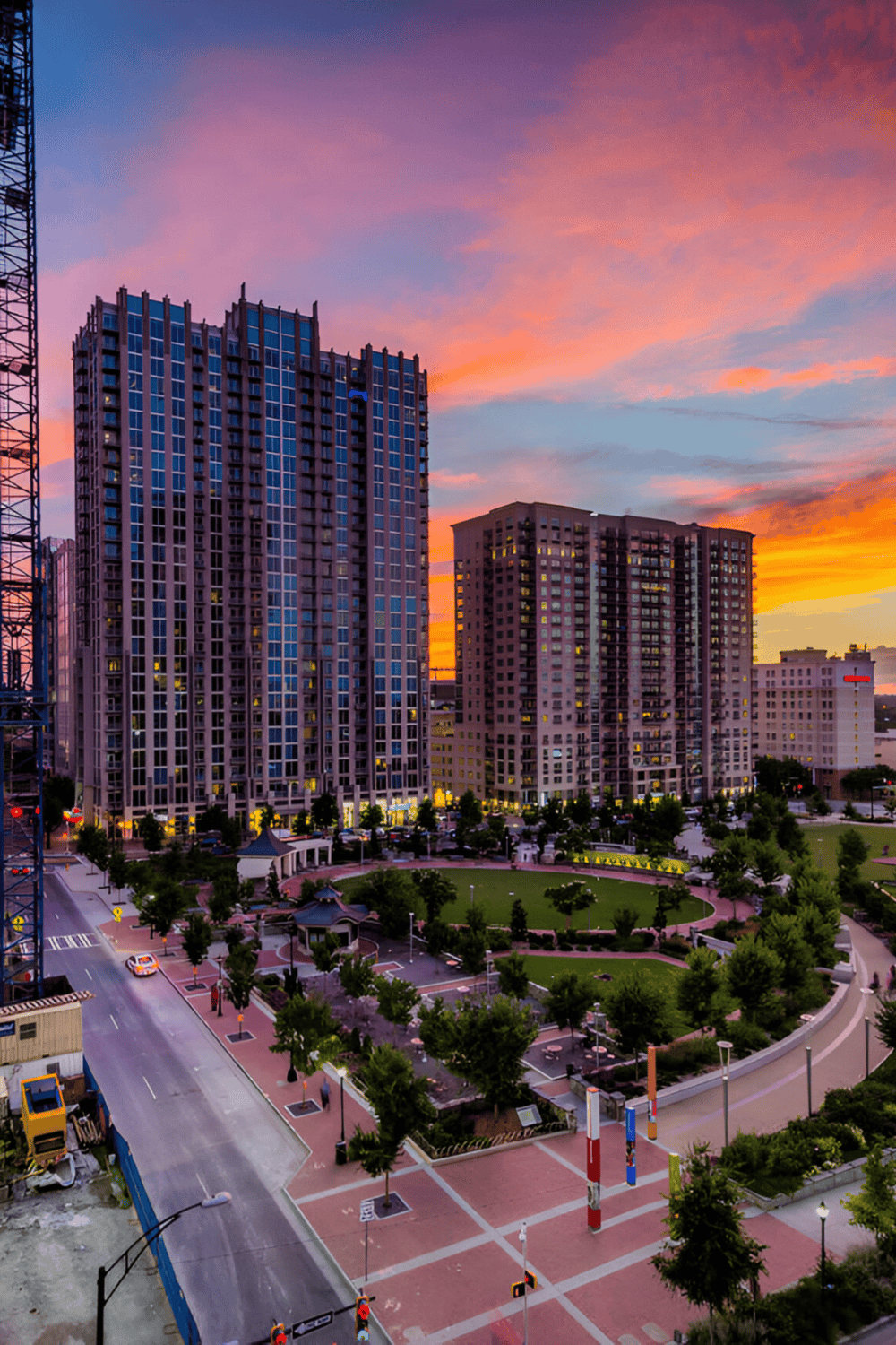 Modern cityscape with high-rise buildings during vibrant sunset, ideal for urban navigation and local business directories.