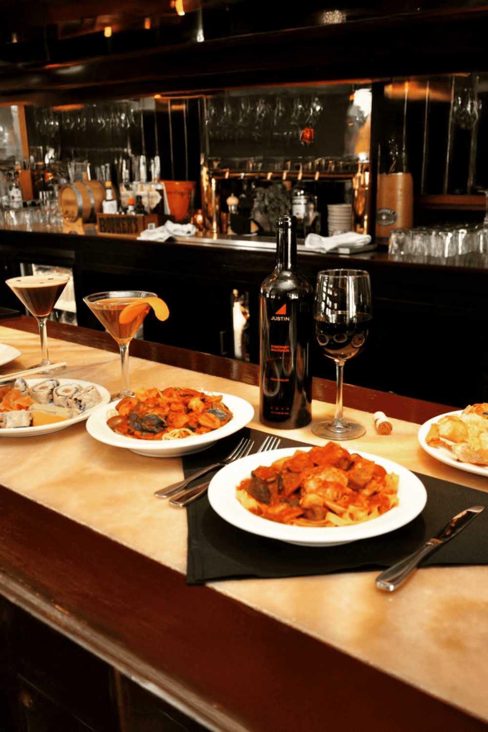 Succulent Italian pasta dishes with wine and cocktails at a cozy restaurant bar.