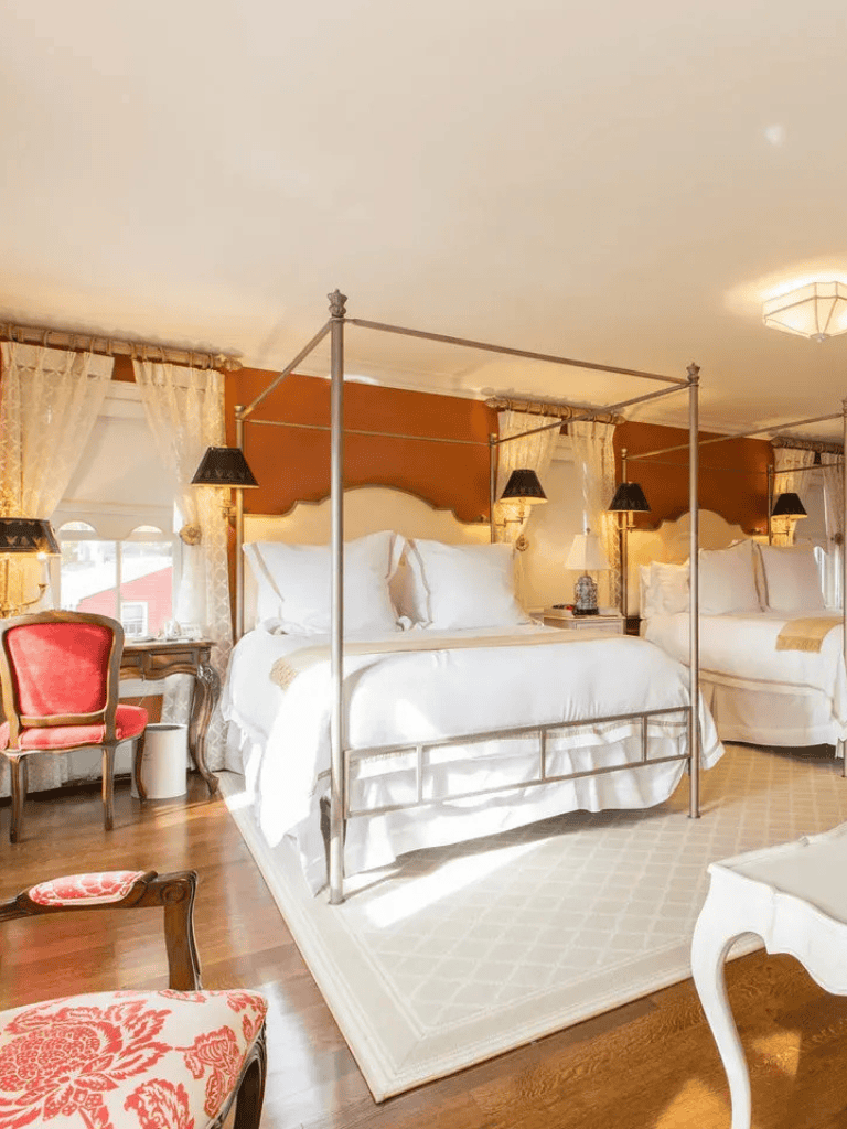 Luxurious bedroom with elegant canopy beds and vintage furniture, perfect for a cozy and stylish stay.