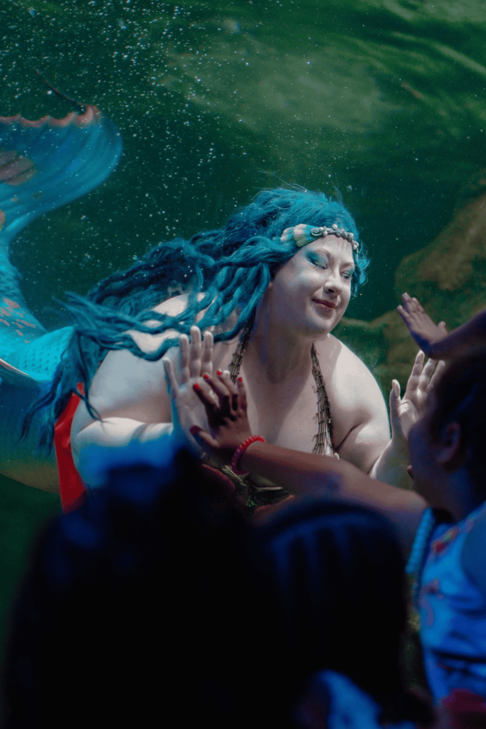 Colorful mermaid underwater during a themed event or photo shoot, showcasing fantasy and aquatic character exploration.