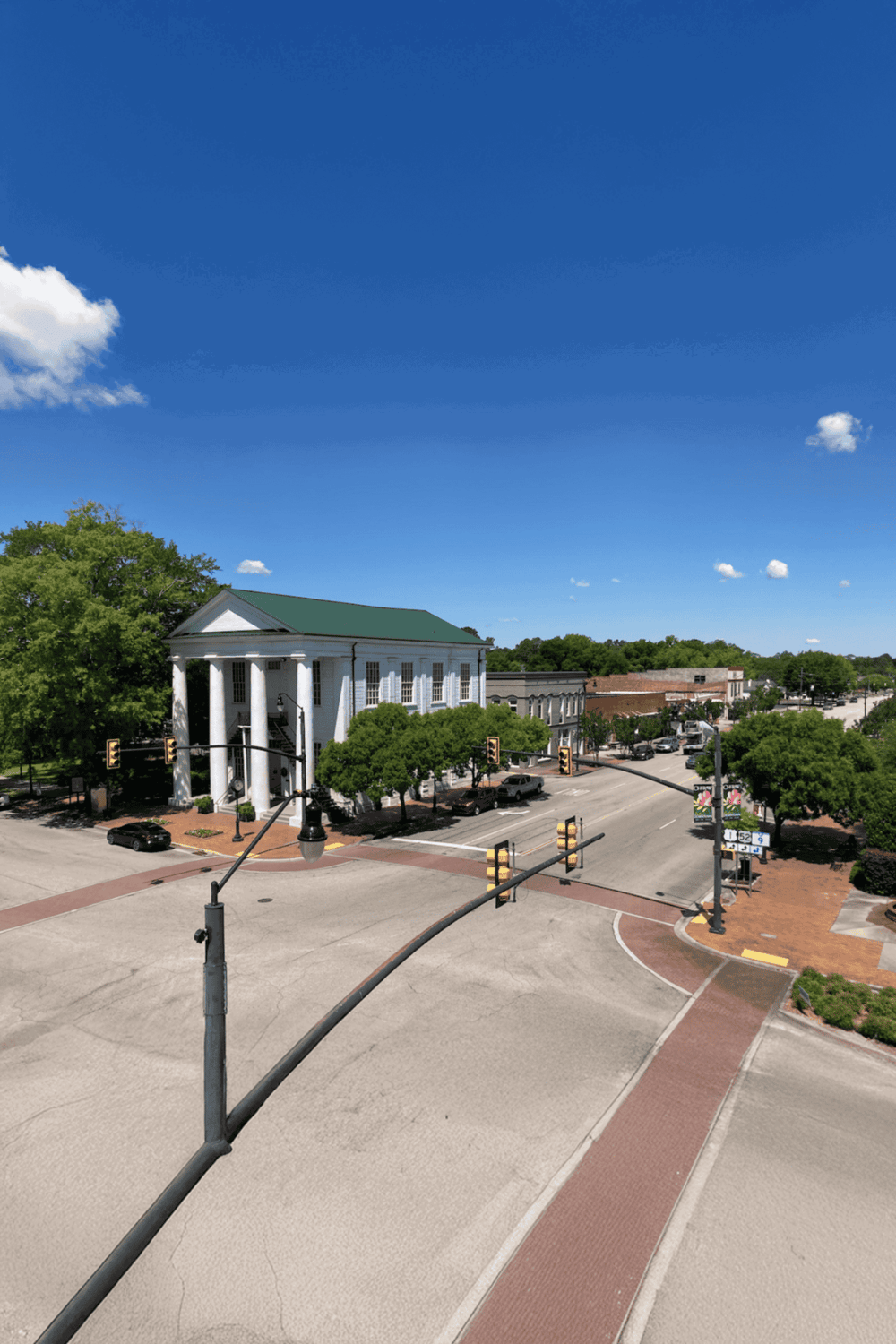 Historic courthouse in downtown with clear skies and lush green trees, ideal for exploring local government and attractions.