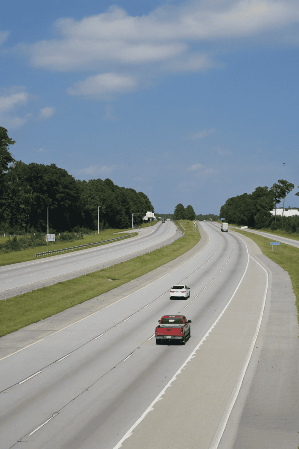 Open highway with multiple lanes and vehicles during daytime.