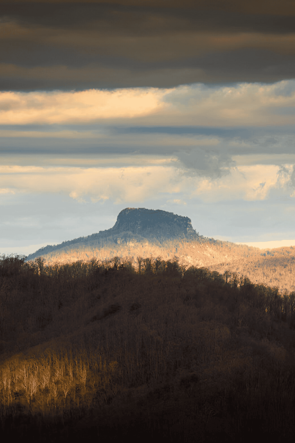 1. Rock formation with scenic mountain landscape under dramatic sky.