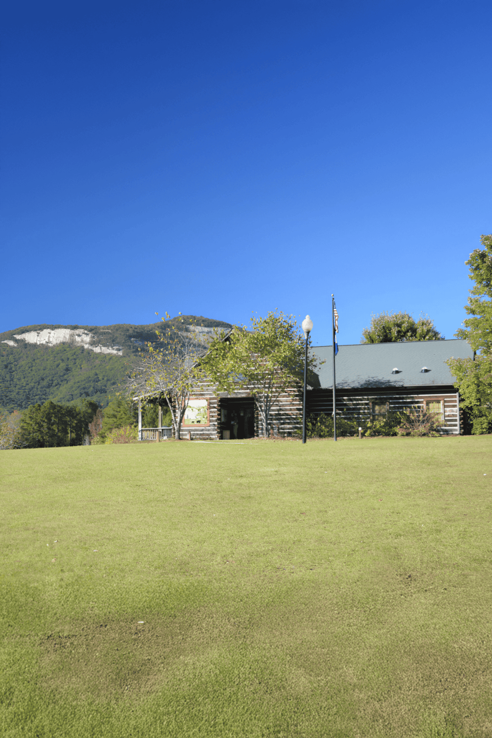 1. Modern rustic building with mountain view and clear blue sky in the background.