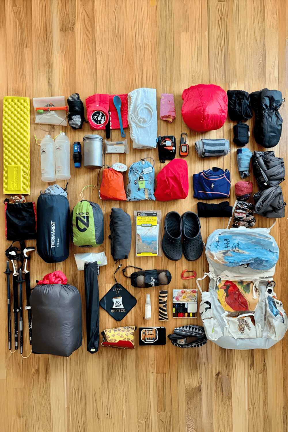1. Comprehensive trekking gear organized on wooden floor for outdoor adventure and hiking trips.