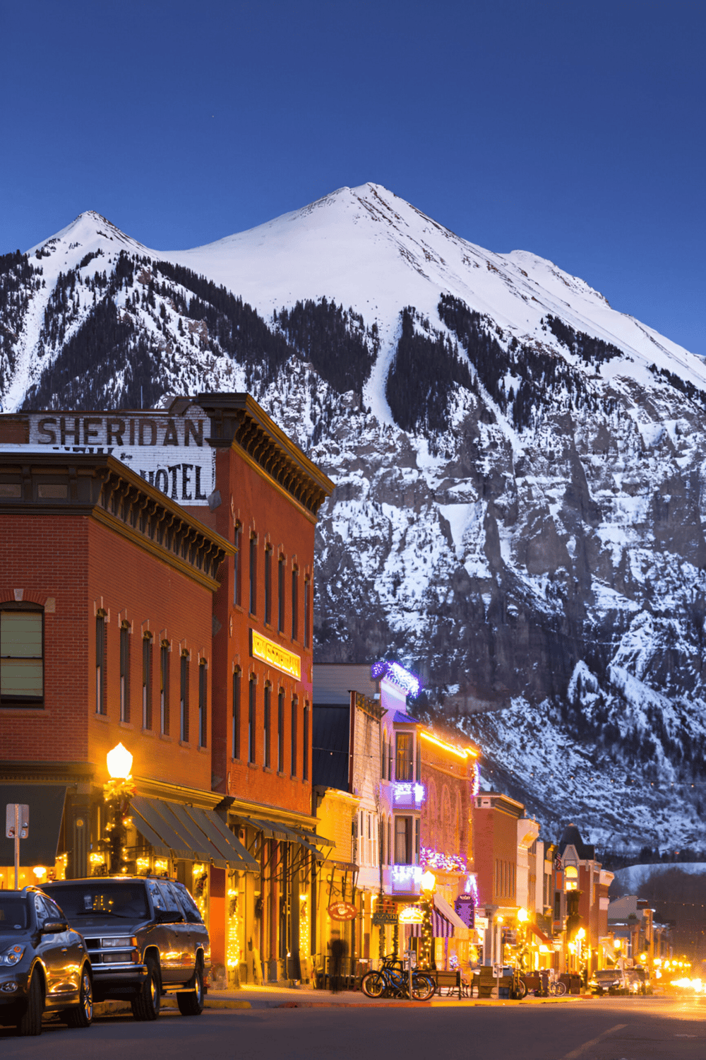 Snow-capped Mount Sherman behind Aurora, Colorado downtown district with vibrant nightlife.