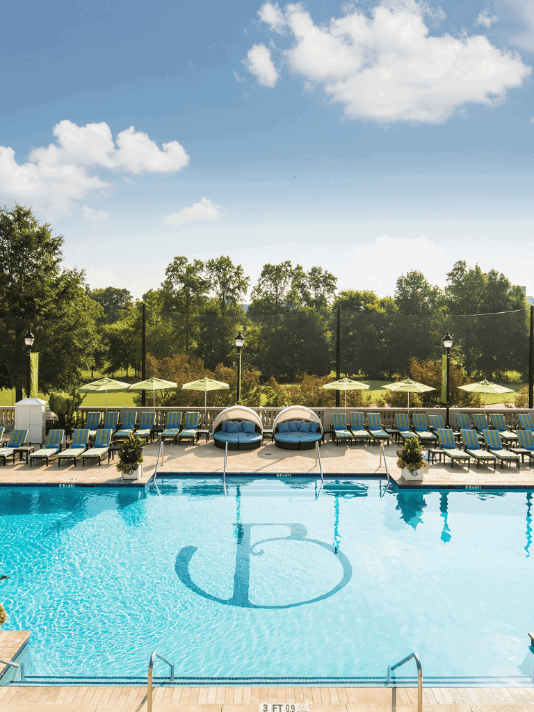 Luxurious outdoor swimming pool with lounge chairs and shaded seating, perfect for relaxation and leisure.