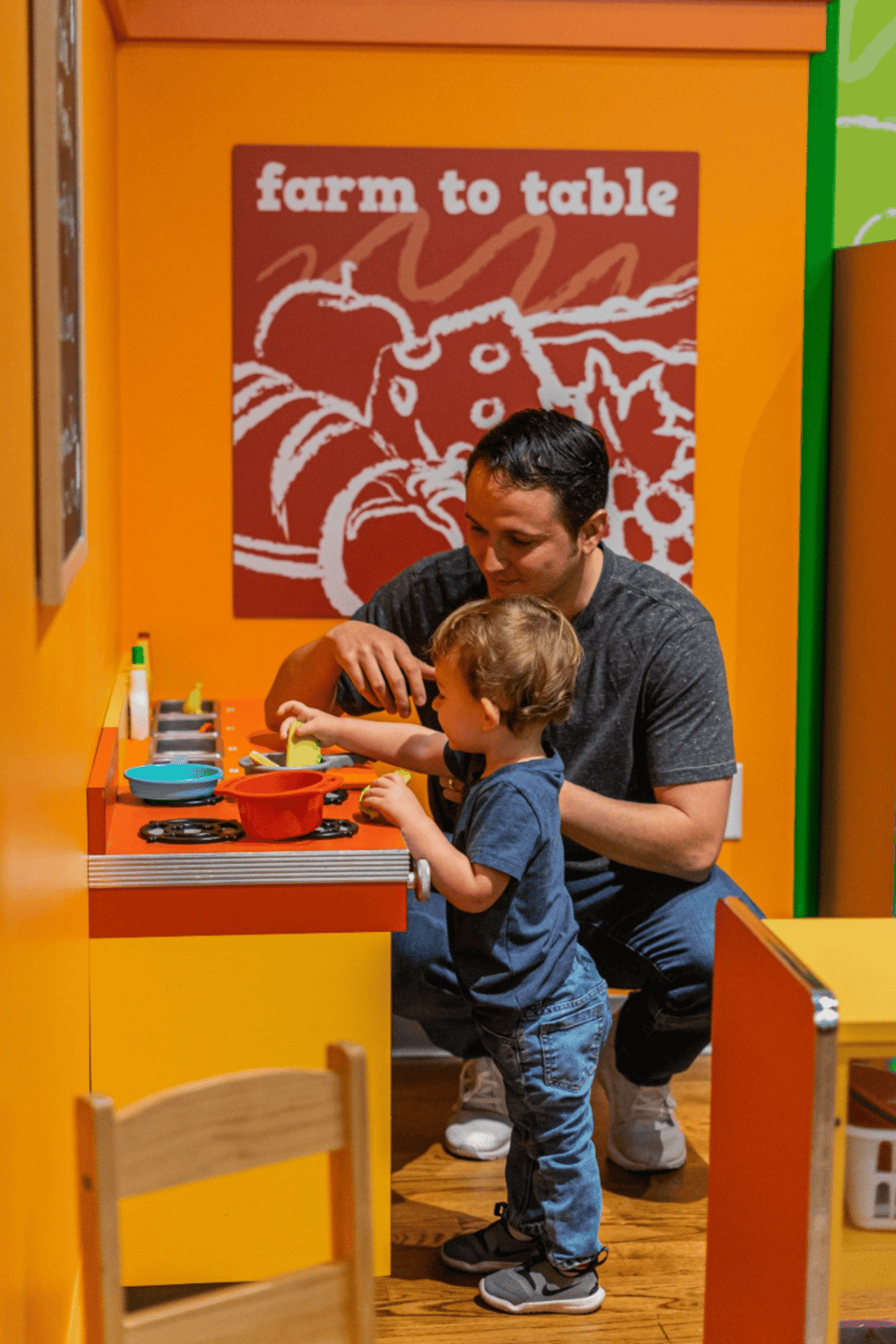 Cooking activity for kids at farm-themed indoor play area.