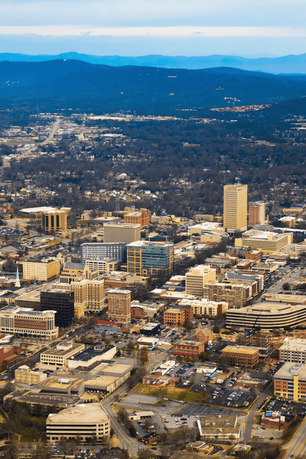 Aerial view of downtown with cityscape, mountains, and highways in the background, showcasing QuestForDirections' navigation solutions.
