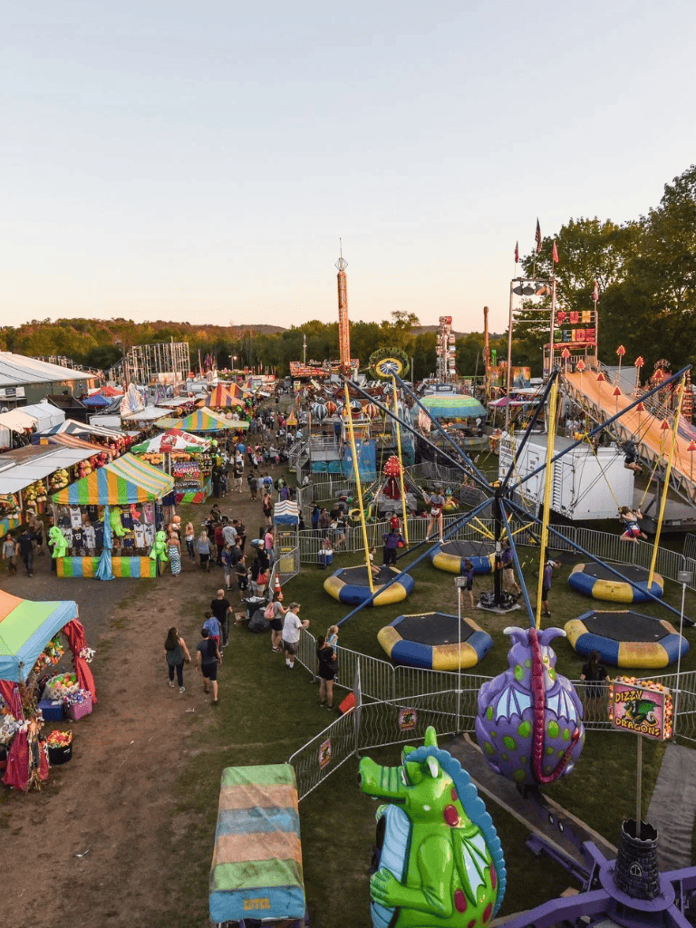 Colorful amusement park rides and carnival games at evening fair, family fun, kids rides, Ferris wheel, attraction, outdoor entertainment.