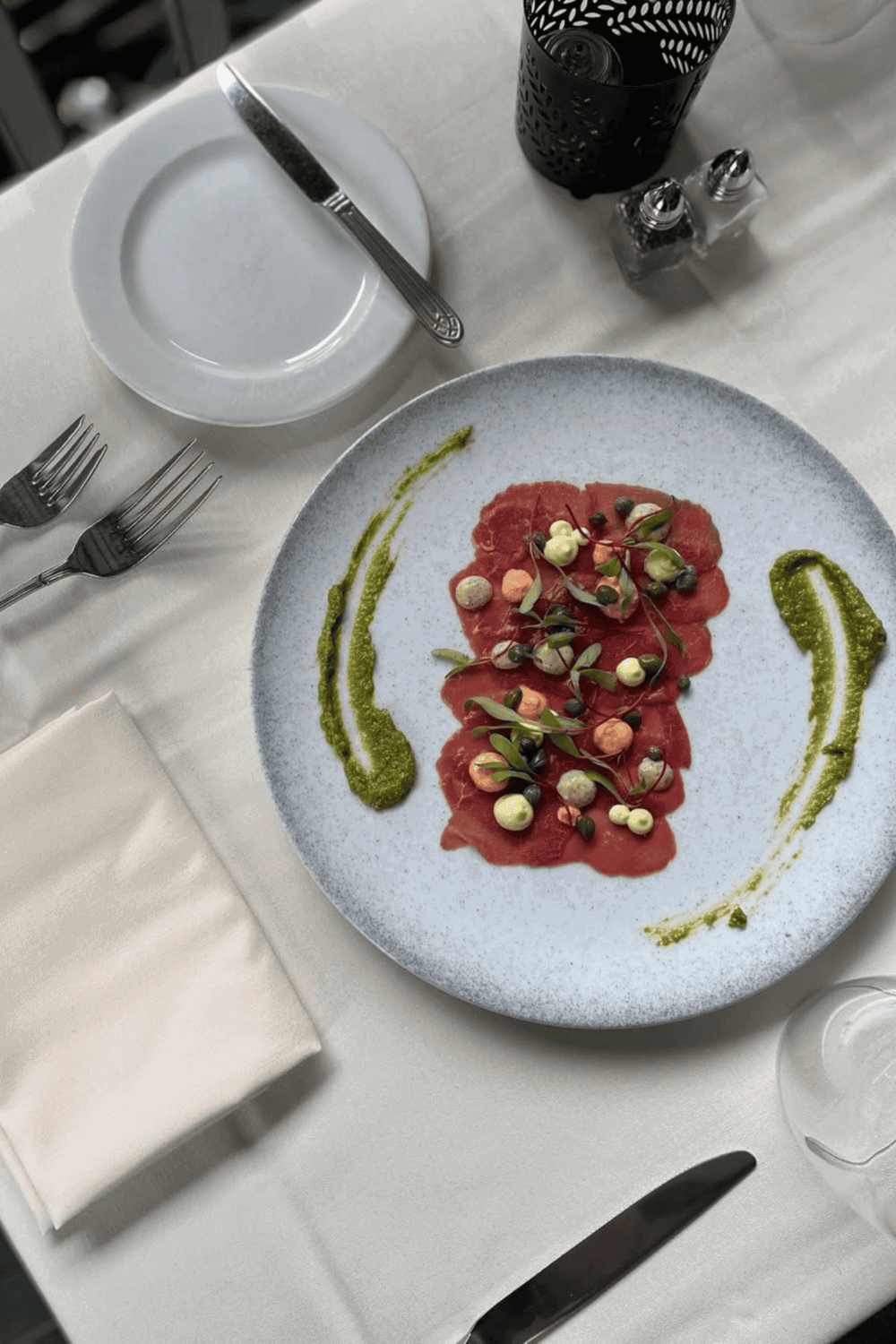 Premium steak tartare with fresh herbs and colorful garnish at QuestForDirections restaurant.