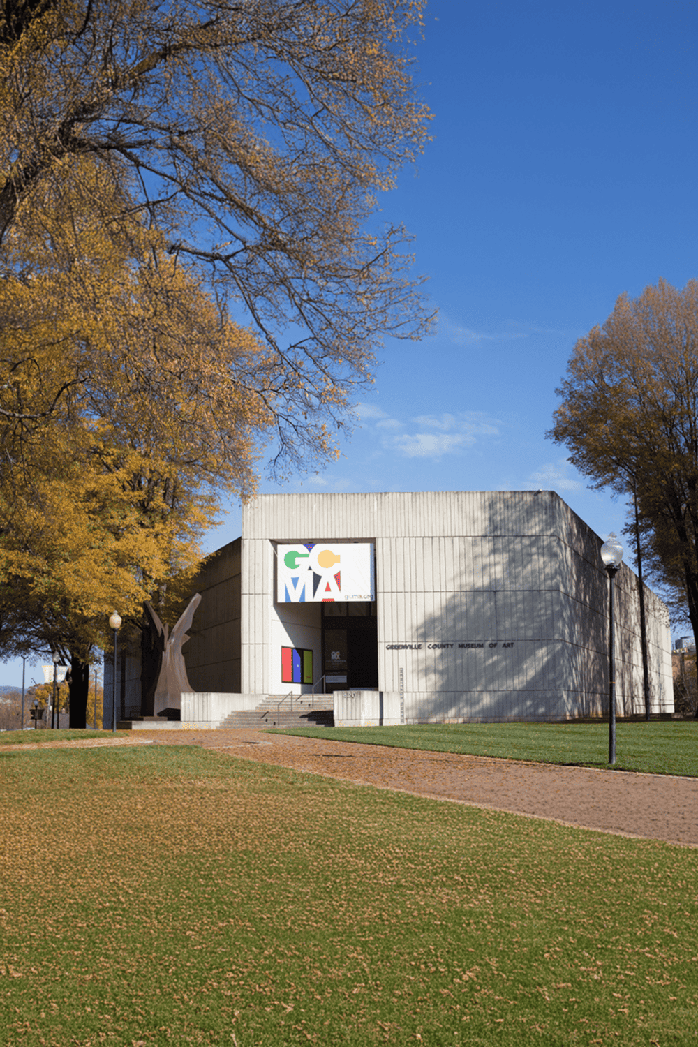 Colorful Greenville County Museum of Art in autumn, surrounded by trees with golden leaves.