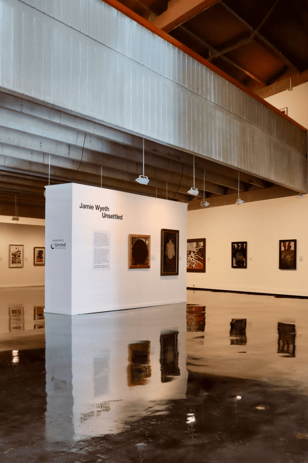 Contemporary art exhibit at Quest For Directions with framed paintings on gallery wall.