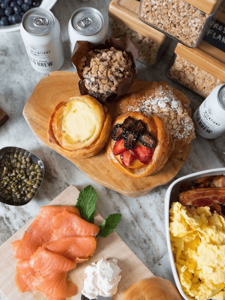 Cream cheese Danish pastries with fresh strawberries and chocolate drizzle, served on a wooden platter.